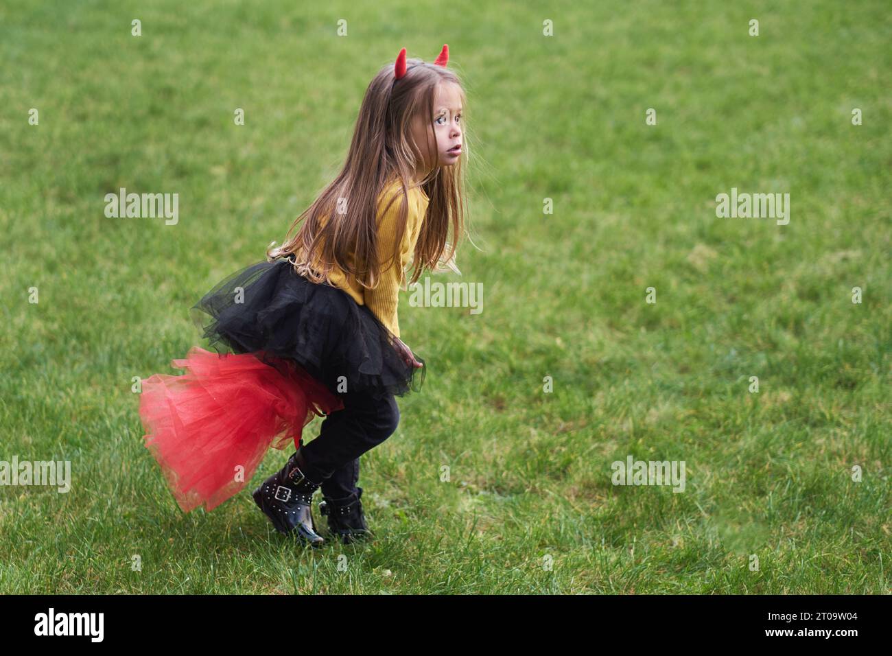 Portrait de fille dans un costume de diable Halloween avec des cornes. Enfance heureuse. All Saints Day. Banque D'Images