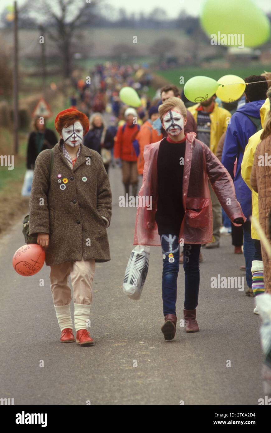 Aldermaston à Greenham Common Pâques 1983. Les manifestants de la paix ont formé une chaîne humaine qui s'étendait sur 14 kilomètres. Ils ont tracé une route le long de ce que les manifestants appellent la « Nuclear Valley » dans le Berkshire. La chaîne a commencé à la base aérienne américaine de Greenham Common, a passé devant le centre de recherche nucléaire d'Aldermaston et s'est terminée à l'usine de munitions de Burghfield. Filles avec le symbole CND de peinture pour le visage. ANNÉES 1980 ROYAUME-UNI HOMER SYKES Banque D'Images