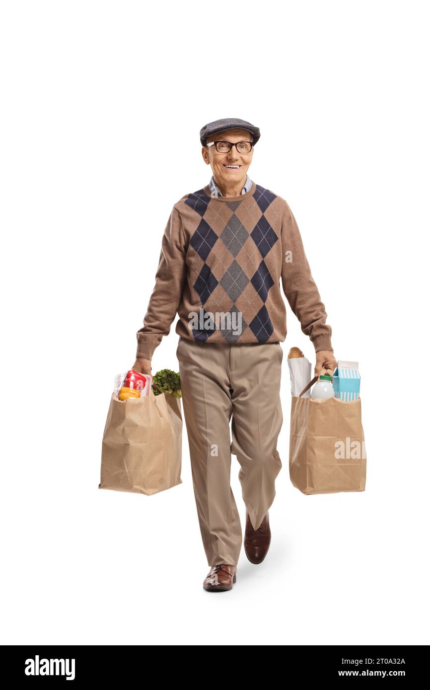 Homme âgé marchant avec des sacs d'épicerie et souriant isolé sur fond blanc Banque D'Images