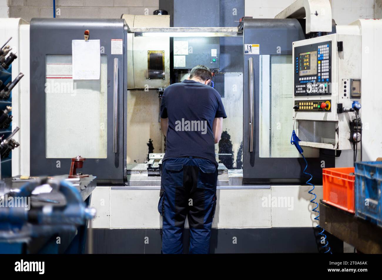 Homme travaillant sur une usine de pièces en acier avec une machine industrielle professionnelle Banque D'Images
