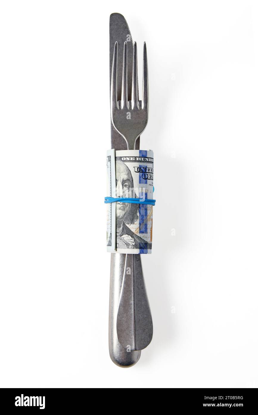 Fourchette à couverts et couteau enveloppés dans des billets de cent dollars avec portrait Benjamin Franklin isolé sur fond blanc. Concept de basculement pour serveur. Banque D'Images