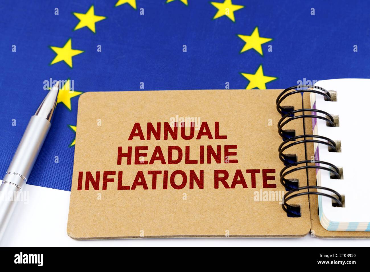 Concept d'économie et de finance. Sur le drapeau de l'Union européenne se trouvent un stylo et un bloc-notes avec l'inscription - taux annuel global d'inflation. Banque D'Images