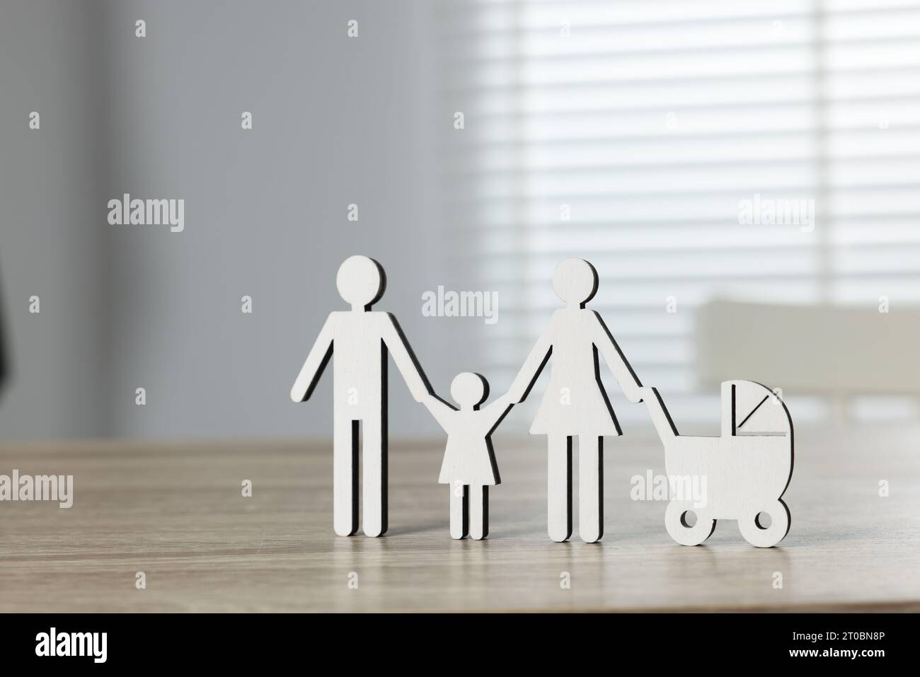 Droit de la famille. Figure de parents avec enfants sur une table en bois clair Banque D'Images