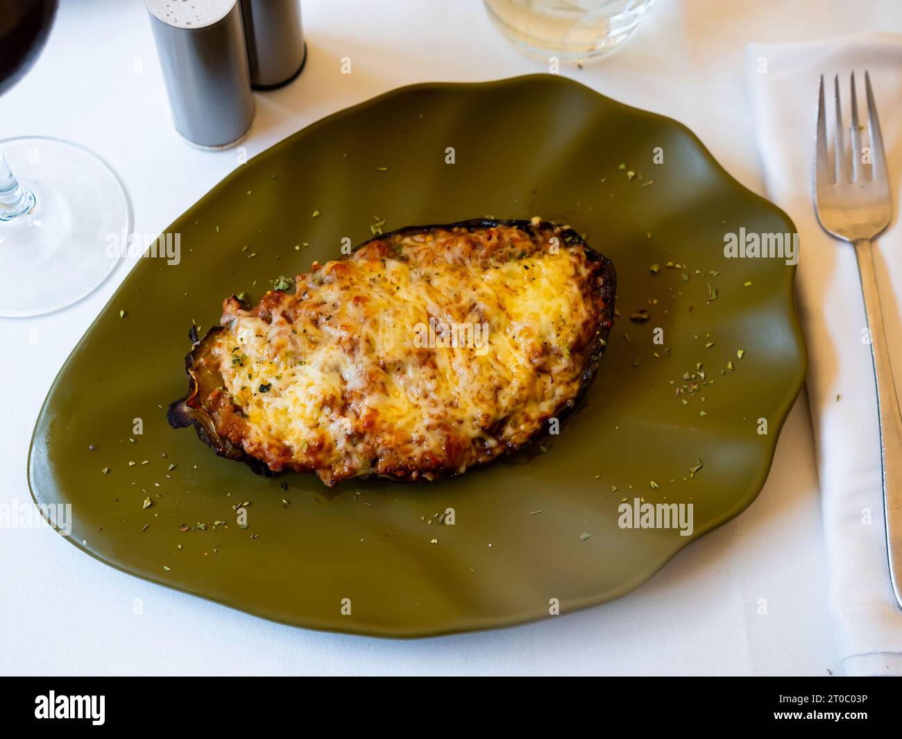 Moitié cuite au four d'aubergines gratinées au fromage Banque D'Images