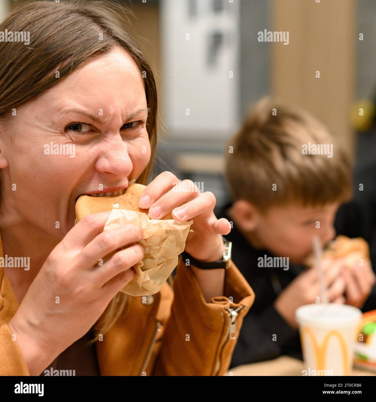 Ivano-Frankivsk, Ukraine 7 juin 2023 : une jeune fille mange un Burger chez McDonald's. Banque D'Images