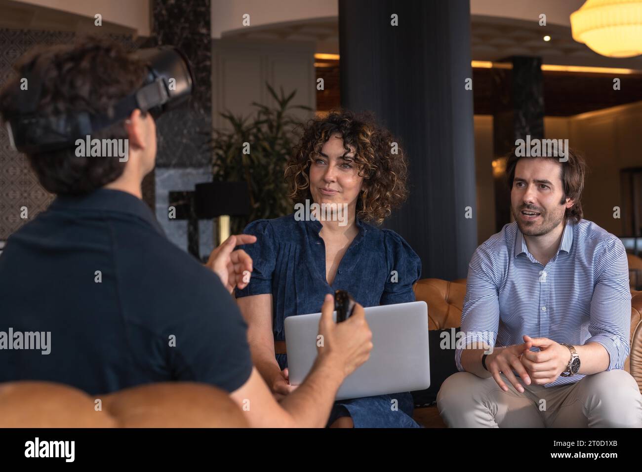 Femme d'affaires utilisant la tablette avec collègue gesturant en portant simulateur de réalité virtuelle Banque D'Images