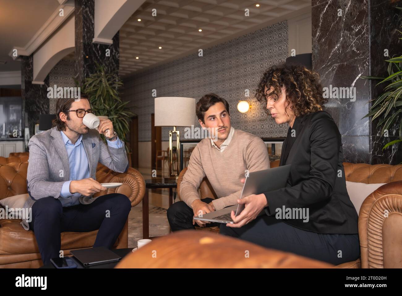 Rencontre avec trois hommes d'affaires dans la cafétéria d'un hôtel Banque D'Images