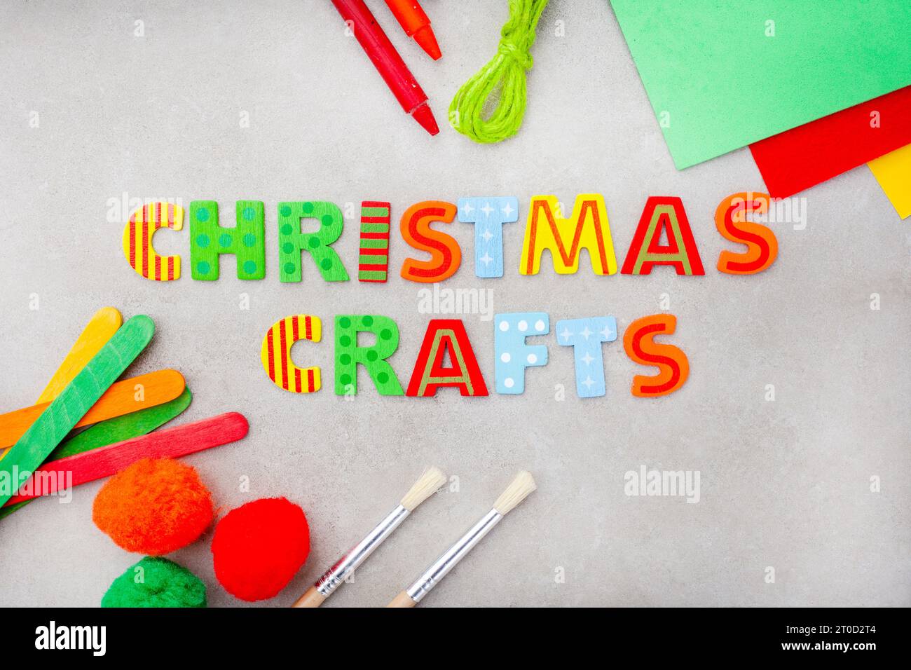 Artisanat de Noël en lettrage lumineux avec des fournitures artisanales colorées sur une surface grise tachetée Banque D'Images