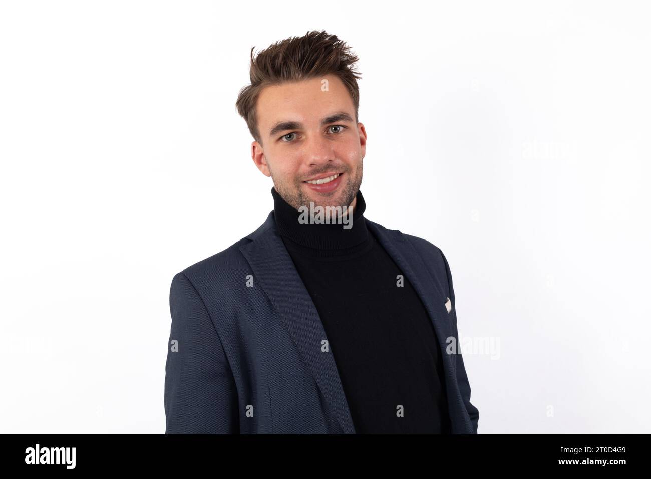 Un beau jeune homme, vêtu d'une veste et d'un col polo, sourit radieusement dans un gros plan captivant Banque D'Images