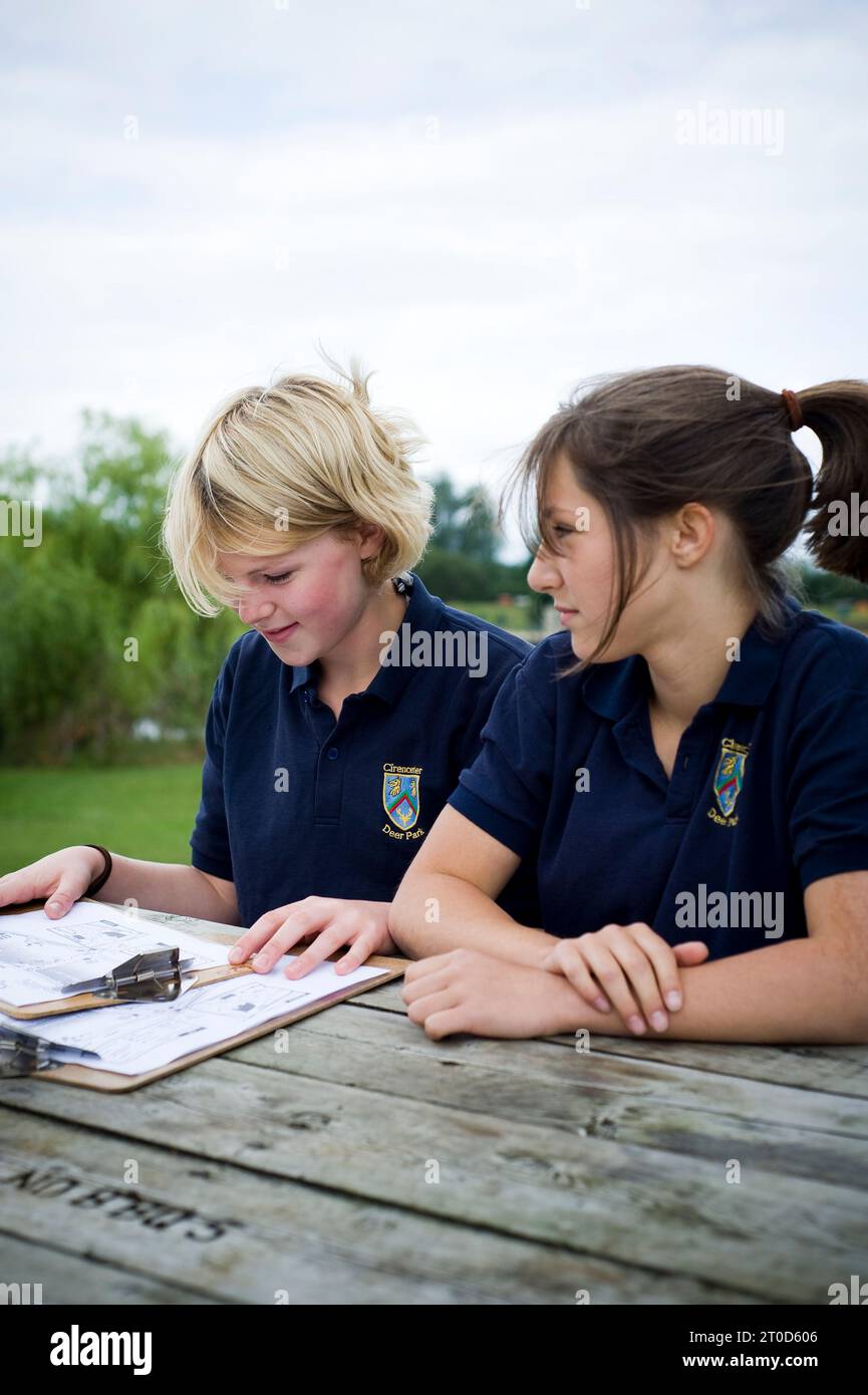 Les élèves adolescentes du secondaire s'orientent alors qu'elles suivent un cours d'orientation vers l'extérieur Banque D'Images