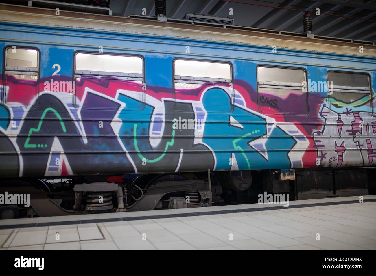 Un vieux train parsemé de graffitis traverse la gare principale souterraine de Prokop à Belgrade, en Serbie Banque D'Images