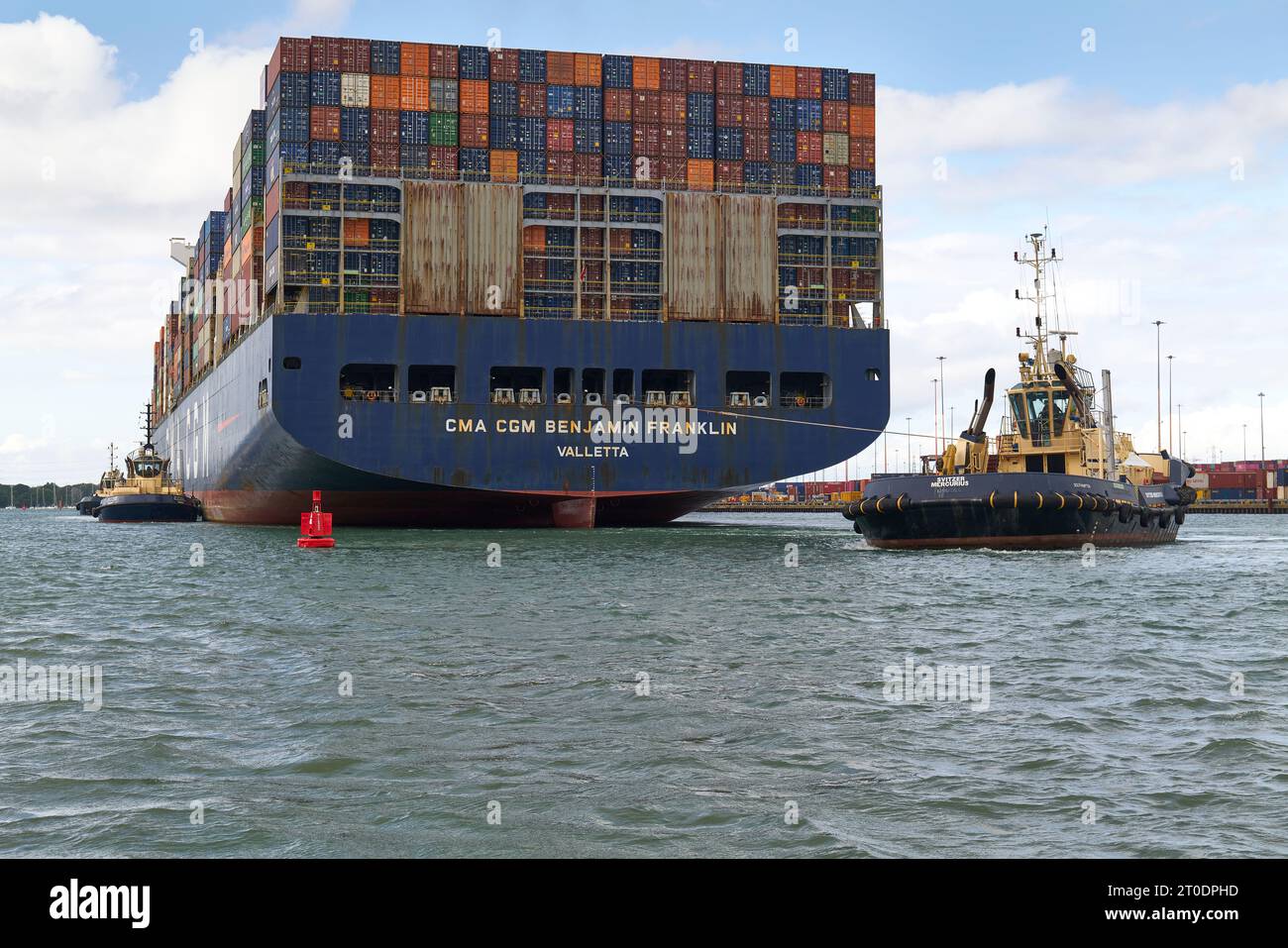 Le Tug SVITZER MERCURIUS escorte l'ULCS CMA CGM BENJAMIN FRANKLIN vers son poste d'amarrage au Southampton Container terminal, Royaume-Uni. Banque D'Images