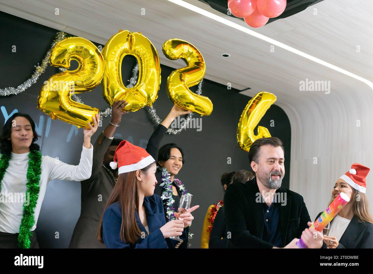 Bonne année 2024 !! Un groupe de gens d'affaires divers et collègues s'amusant ensemble à une fête du nouvel an d'affaires. Une célébration de travail d'équipe d'un Banque D'Images