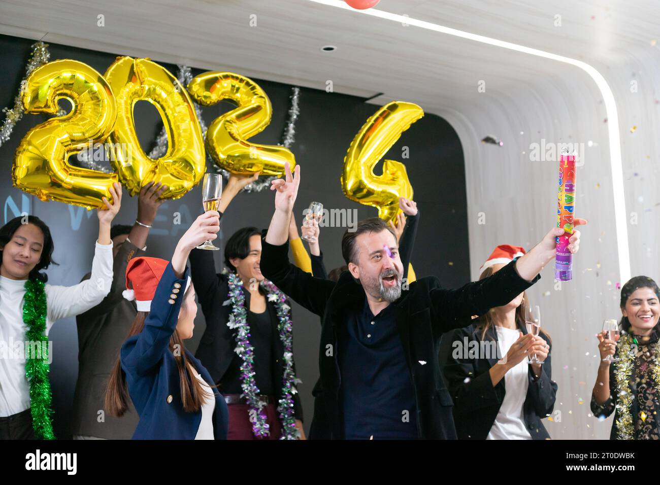 Bonne année 2024 !! Un groupe de gens d'affaires divers et collègues s'amusant ensemble à une fête du nouvel an d'affaires. Une célébration de travail d'équipe d'un Banque D'Images