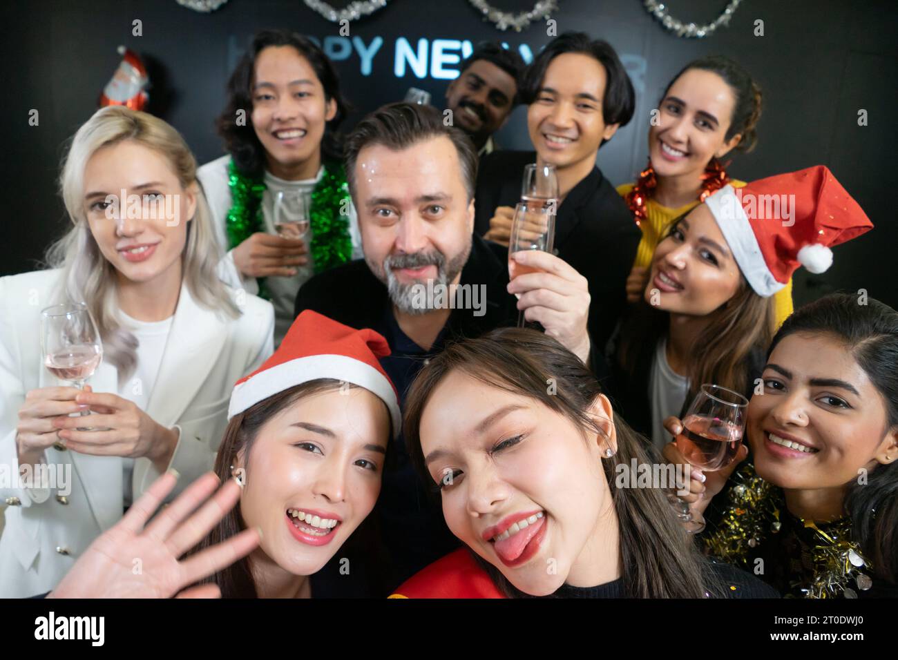 Prenons un selfie !! Un groupe de gens d'affaires divers et collègues s'amusant ensemble à une fête du nouvel an d'affaires. Une célébration de travail d'équipe d'un Banque D'Images