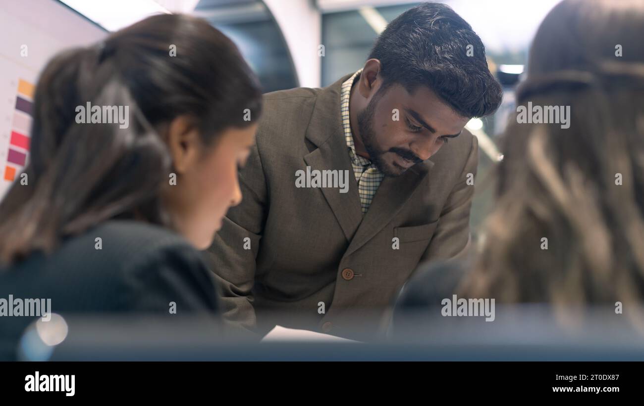 Un patron d'entreprise indien donnant des briefings à un travailleur d'équipe. Communication d'entreprise dans une réunion de travail d'équipe. Banque D'Images