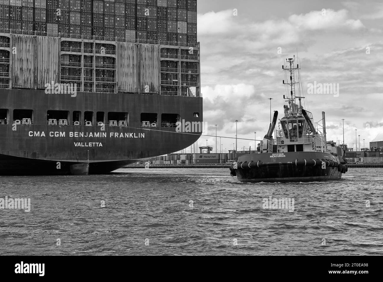 Le Tug SVITZER MERCURIUS escorte l'ULCS CMA CGM BENJAMIN FRANKLIN vers son poste d'amarrage au Southampton Container terminal, Royaume-Uni. Banque D'Images