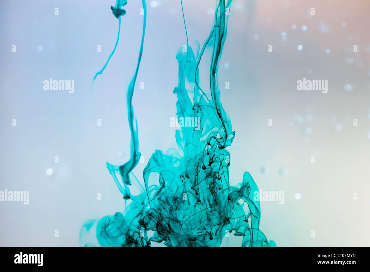 Colorant bleuâtre tombant dans un liquide clair Banque D'Images