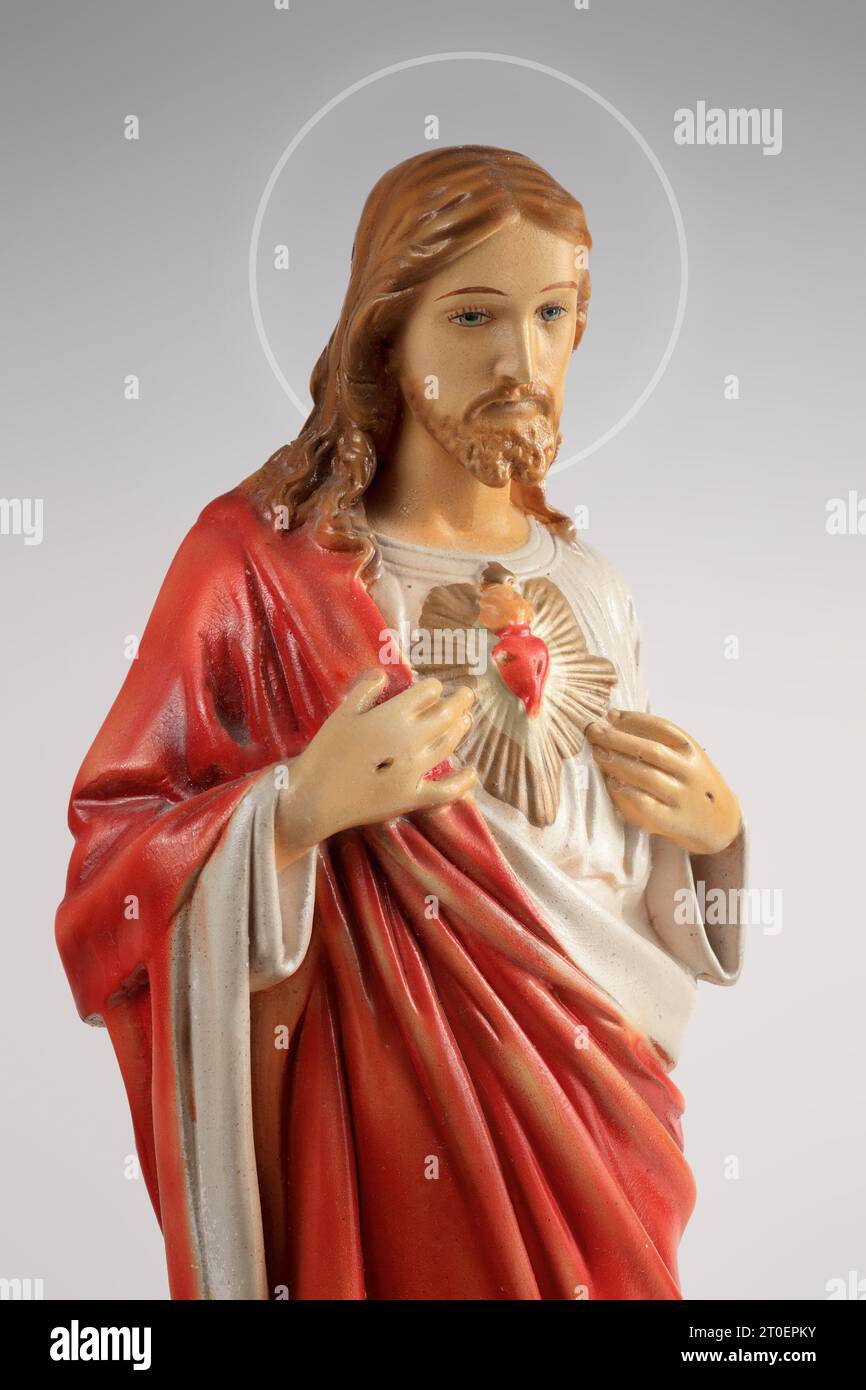 Figurine Jésus vintage avec cœur sacré et esprit Saint lueur. Statue ou figurine de Jésus-Christ en porcelaine ou en argile avec des traits peints. Abstra Banque D'Images