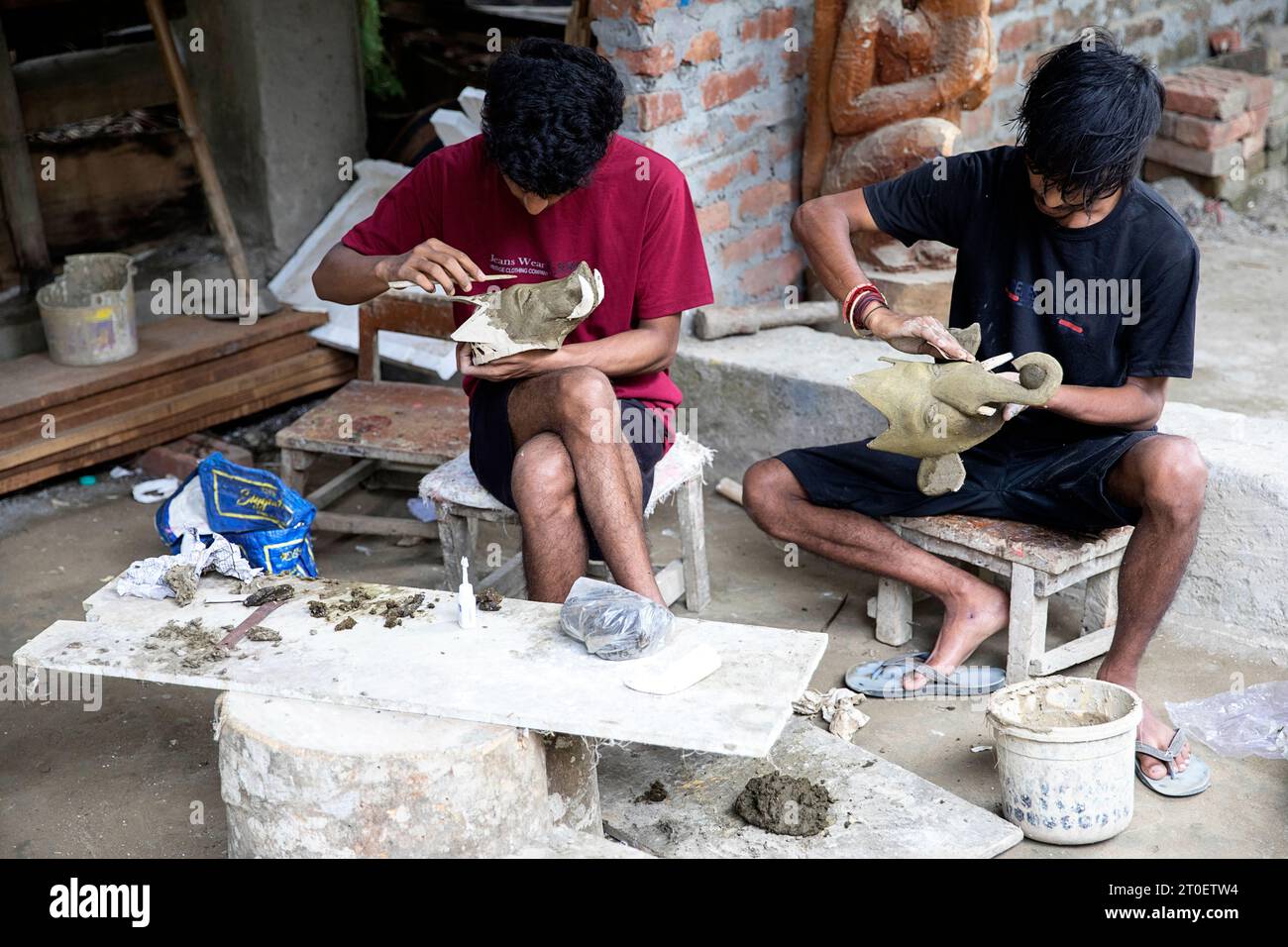 Jeunes hommes fabriquant des masques animaux mythiques traditionnels à partir d'argile, Majuli, Assam, Nord-est de l'Inde Banque D'Images