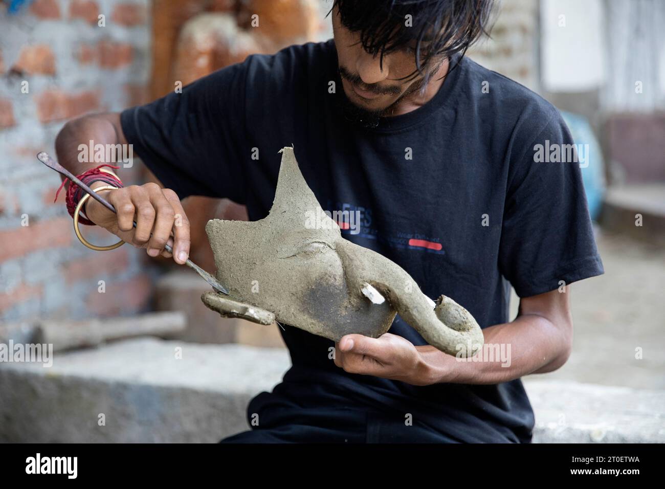 Homme local, fabricant de masques, travaillant sur un nouveau masque traditionnel sur l'île de Majuli à Assam, en Inde Banque D'Images
