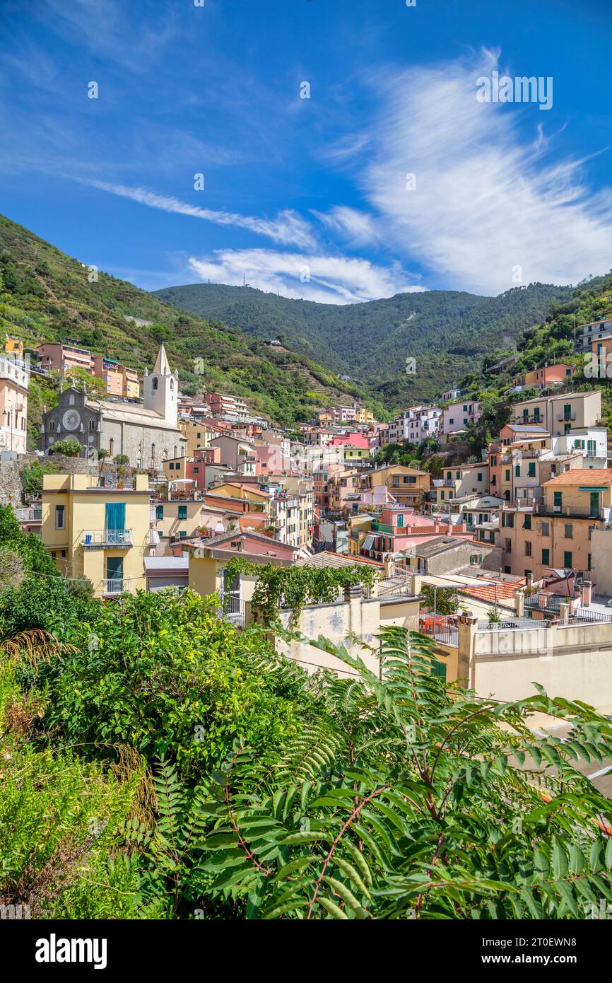 Italie, Ligurie, province de la Spezia, Riomaggiore, maisons de la ville côtière de Cinque Terre, vue vers la montagne avec l'ancienne église de San Giovanni Battista Banque D'Images