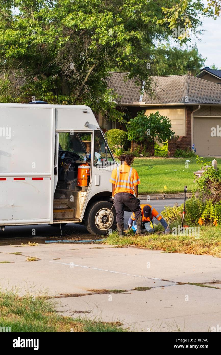 Deux ouvriers de la ville de Wichita creusent un trou près de la rue pour réparer une fuite d'eau. Wichita, Kansas, États-Unis. Banque D'Images
