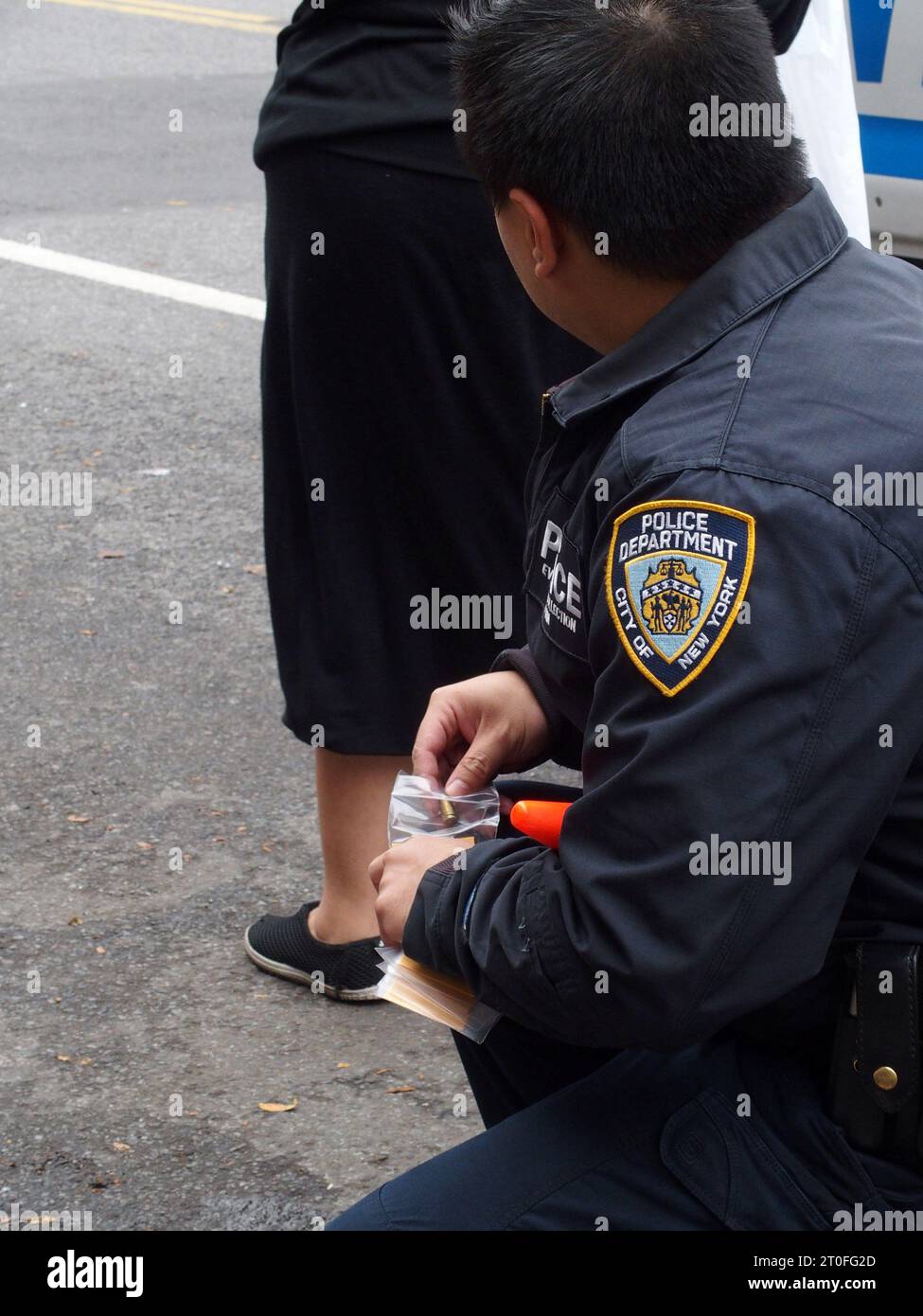 New York, New York, États-Unis. 6 octobre 2023. Brooklyn New York, le 6 octobre 2023. Une fille de seize ans a été abattue dans le quartier Midwood de Brooklyn juste au coin de la Edward R. Murrow High School. Une source non officielle a déclaré que cela semble être lié à un gang et qu'elle n'était pas la cible prévue de la fusillade. La police a emmené une personne en détention. Les cônes orange remplacent les tasses à café qui marquent l'endroit où l'enveloppe de la coquille est sur le sol les sacs de l'agent de collecte de preuves une enveloppe de coquille (image de crédit : © Bruce Cotler/ZUMA Press Wire) À USAGE ÉDITORIAL SEULEMENT! Non destiné à UN USAGE commercial ! Banque D'Images