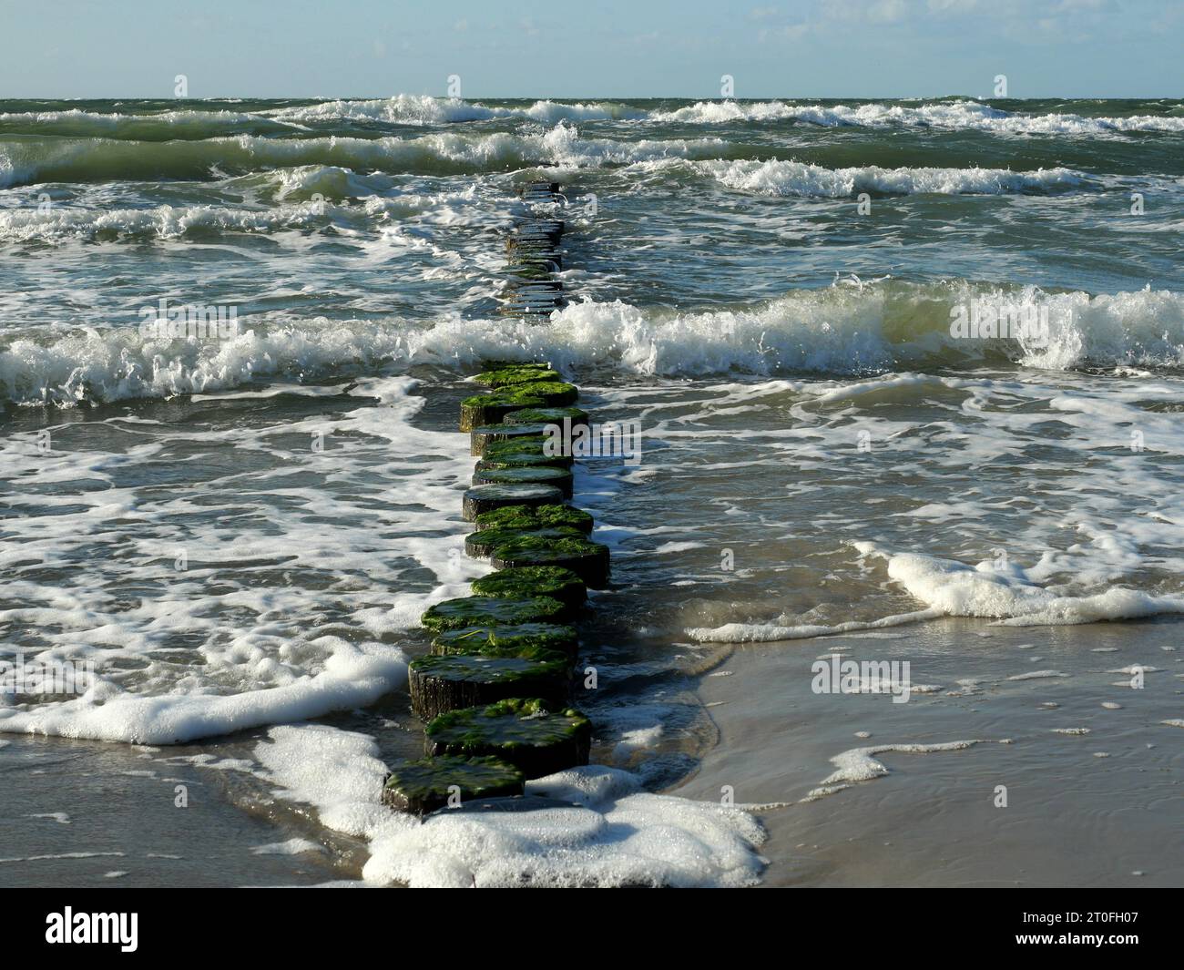 Plage d'Ahrenshoop par temps orageux et soleil. Les hautes vagues sont brisées par les groynes. Banque D'Images