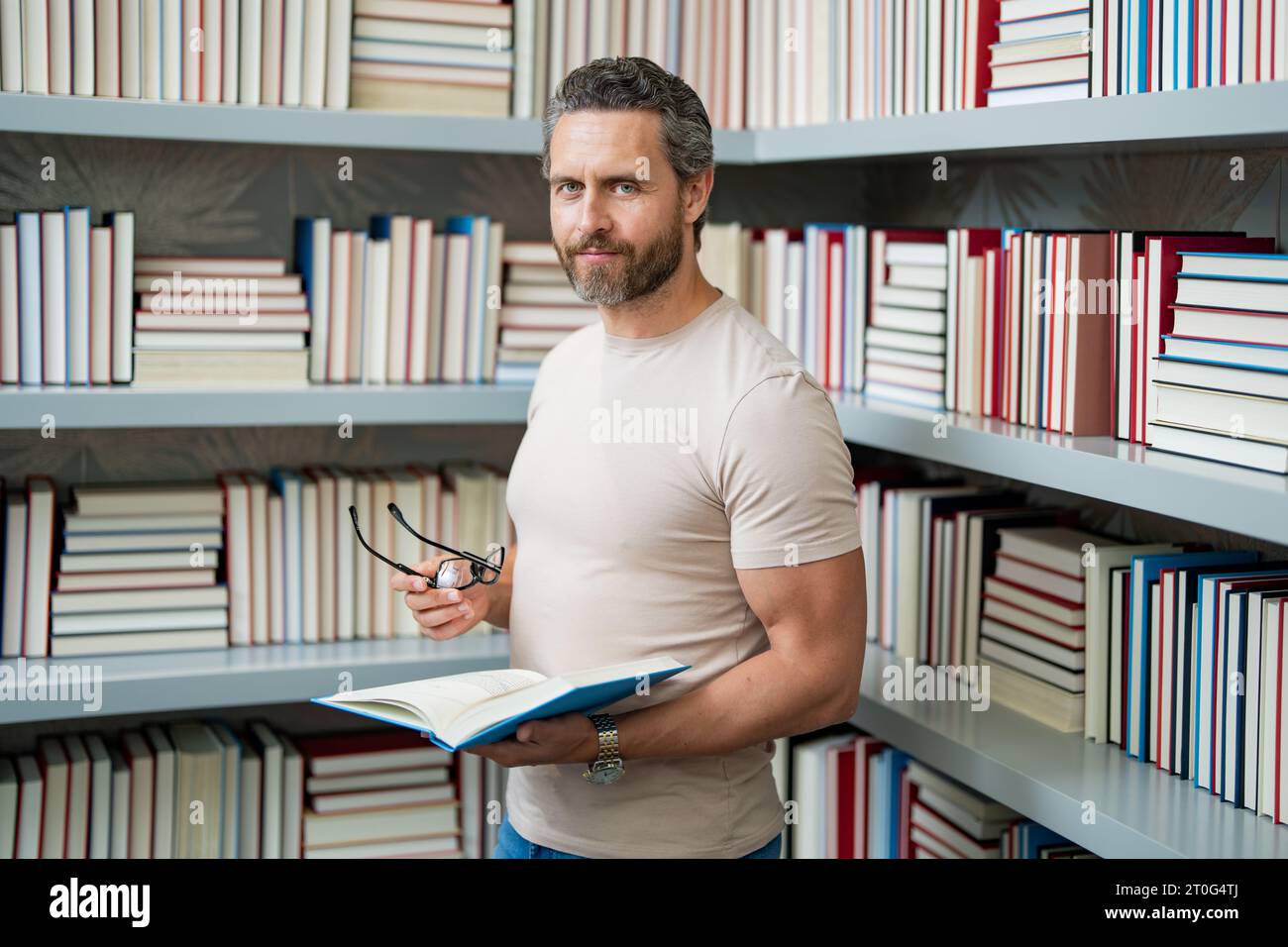 Journée des enseignants. Enseignant en classe scolaire. Connaissance et éducation avec un enseignant d'âge moyen. Professeur hispanique avec livre. Leçon d'enseignement de l'homme en classe Banque D'Images