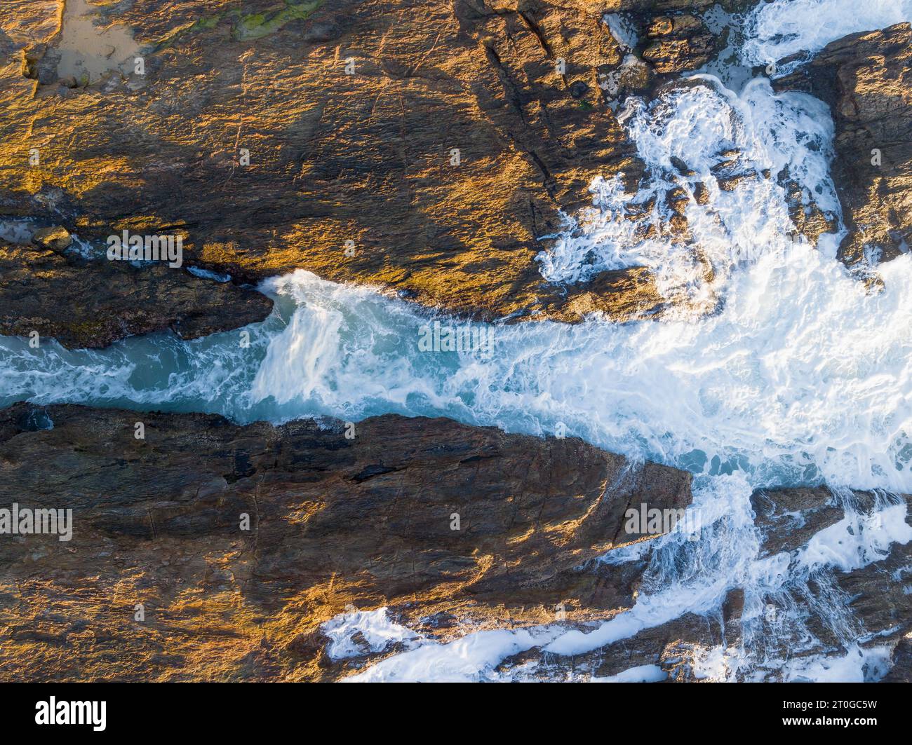 Vue aérienne des vagues déferlant une chute rocheuse sur le littoral accidenté à Nambucca Heads en Nouvelle-Galles du Sud, Australie Banque D'Images