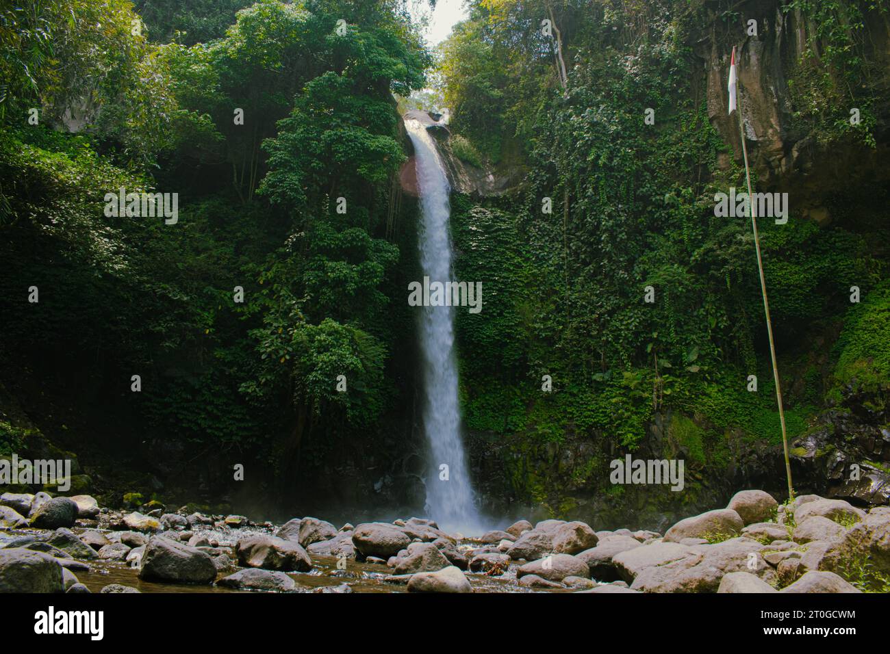 Cascade Coban Jahe à Malang, Java oriental, angle d'en bas avec des rochers, la forêt, et le drapeau indonésien dans la matinée, 06 septembre 2023. Banque D'Images