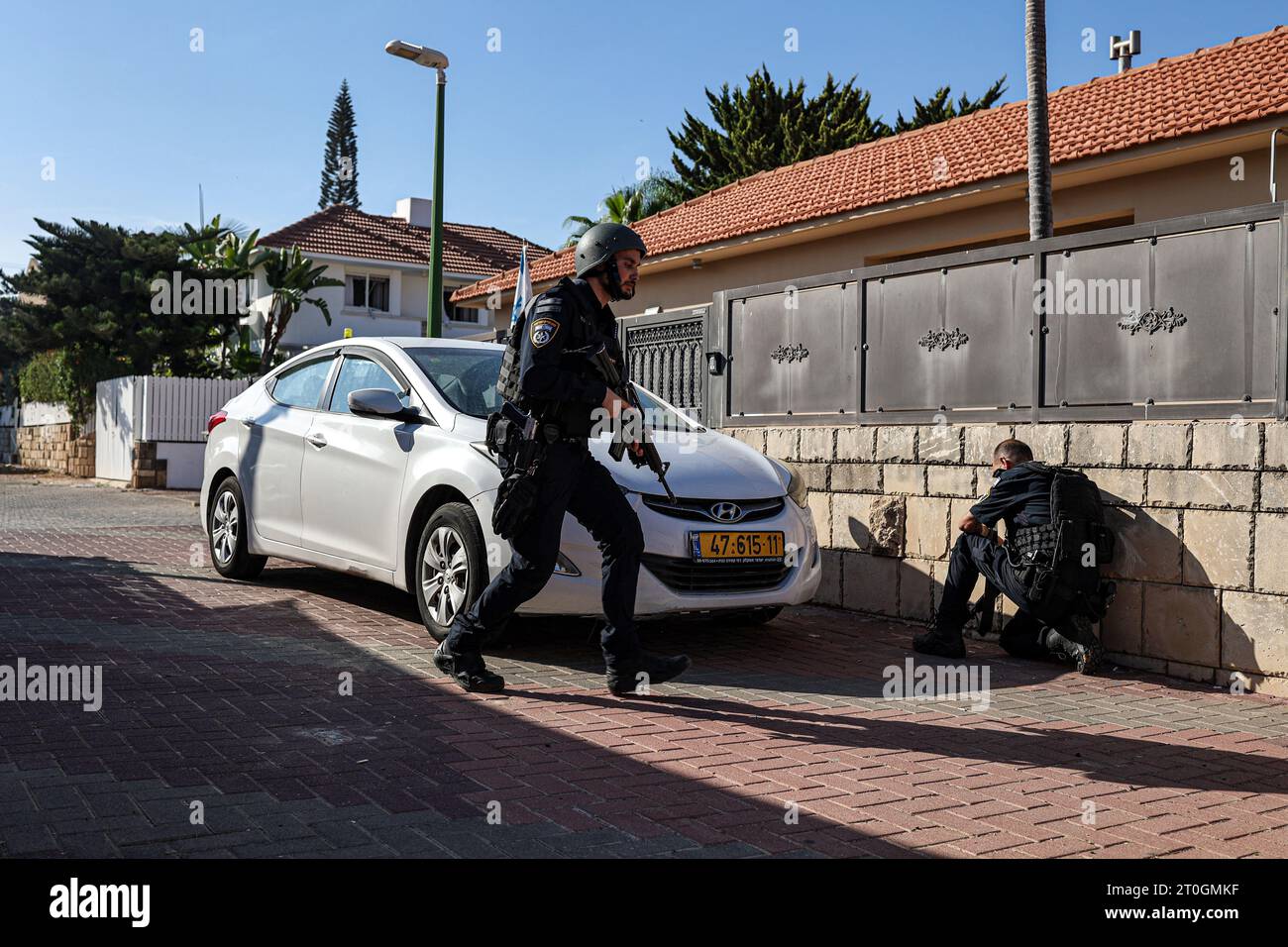 Ashkelon, Israël. 07 octobre 2023. Des policiers israéliens se mettent à couvert derrière un mur lors d’une attaque à la roquette depuis Gaza. Des militants palestiniens à Gaza ont tiré de manière inattendue des dizaines de roquettes sur des cibles israéliennes tôt samedi, a déclaré l’armée israélienne. Crédit : Ilia Yefimovich/dpa/Alamy Live News Banque D'Images