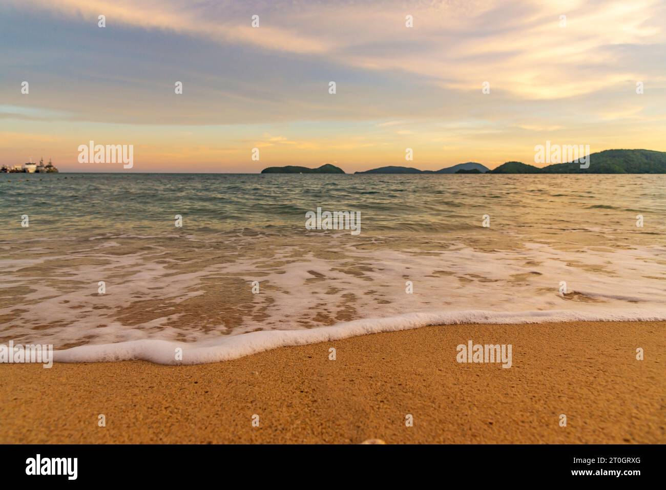 Coucher de soleil ou lever de soleil sur la plage avec ciel nuageux et lumière du soleil en soirée Banque D'Images