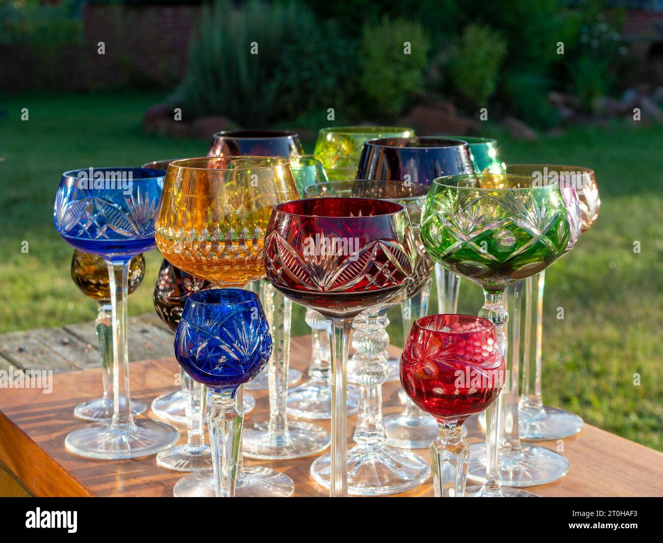 Verres romains en cristal de plomb, verres à vin, verres à champagne, coloré sur la table de fête dans le jardin Banque D'Images