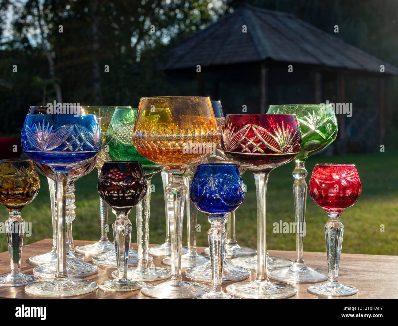 Verres romains en cristal de plomb, verres à vin, verres à champagne, coloré sur la table de fête dans le jardin Banque D'Images