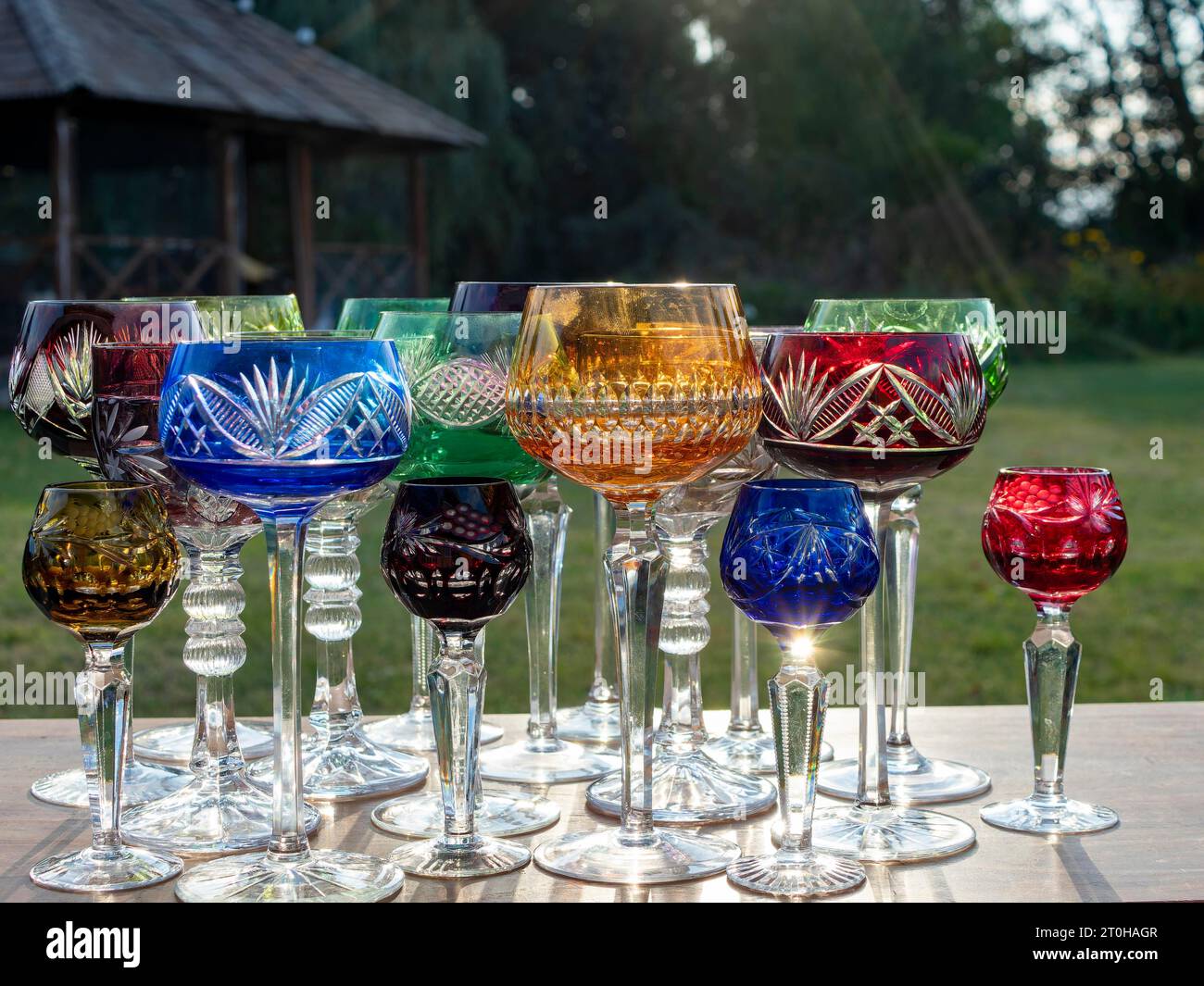 Verres romains en cristal de plomb, verres à vin, verres à champagne, coloré sur la table de fête dans le jardin Banque D'Images