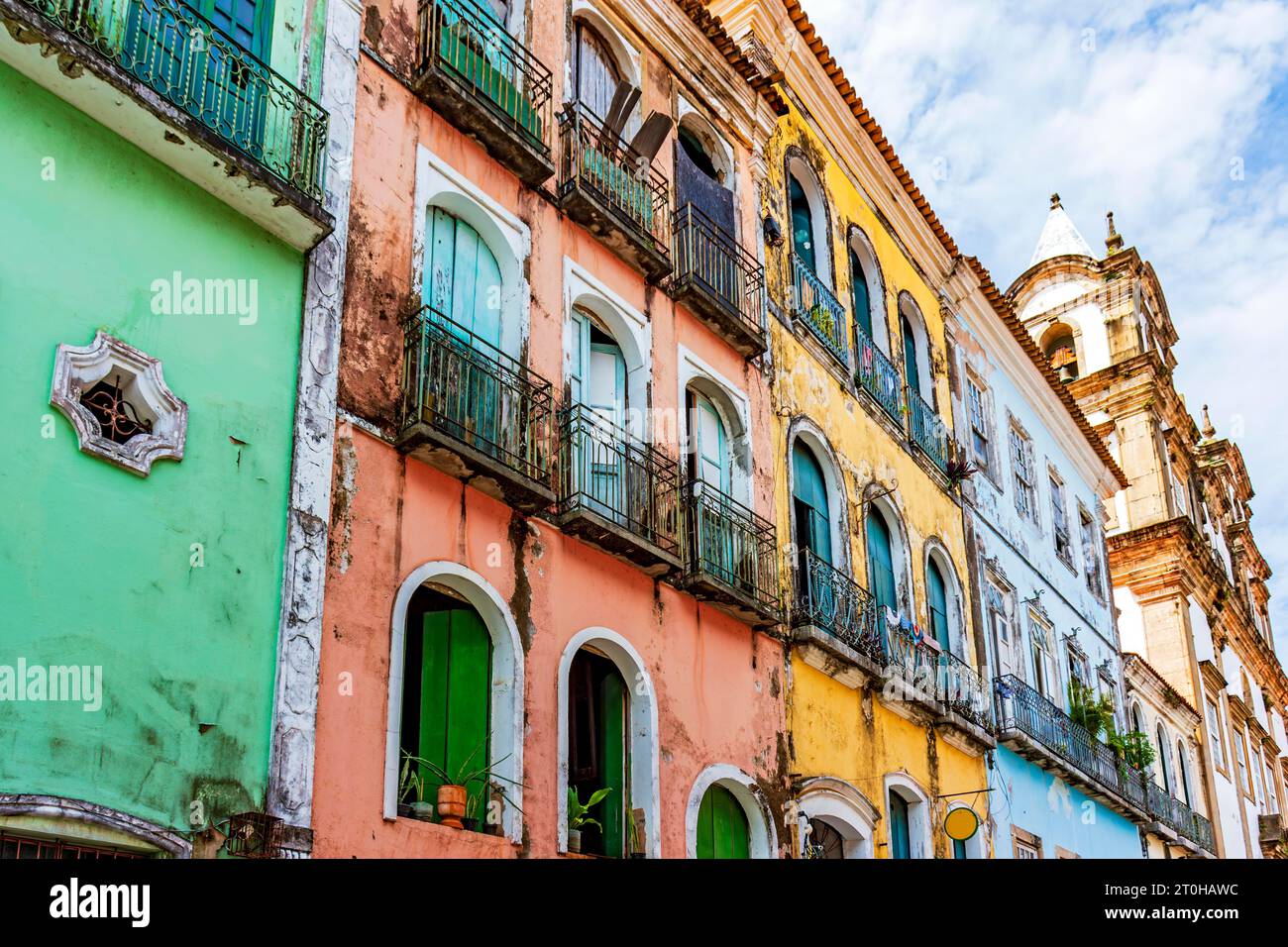 Façades de maisons colorées et église dans le style baroque et colonial endommagé par le temps dans le quartier Pelourinho dans la ville de Salvador, Brésil Banque D'Images