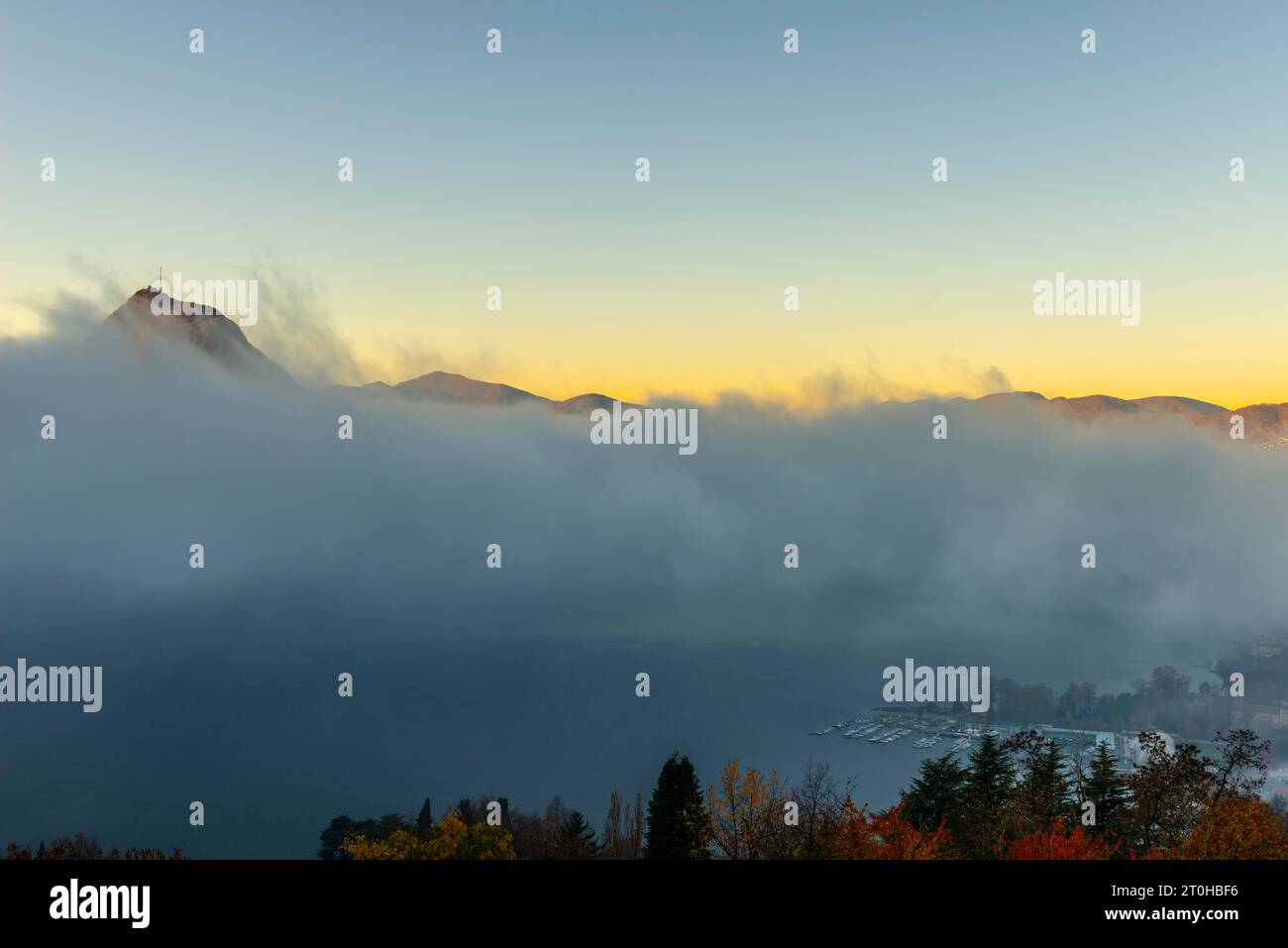 Pic de montagne San Salvatore au-dessus de Cloudscape et du lac de Lugano avec lumière du soleil et ciel clair dans la ville de Lugano, Tessin, Suisse Banque D'Images