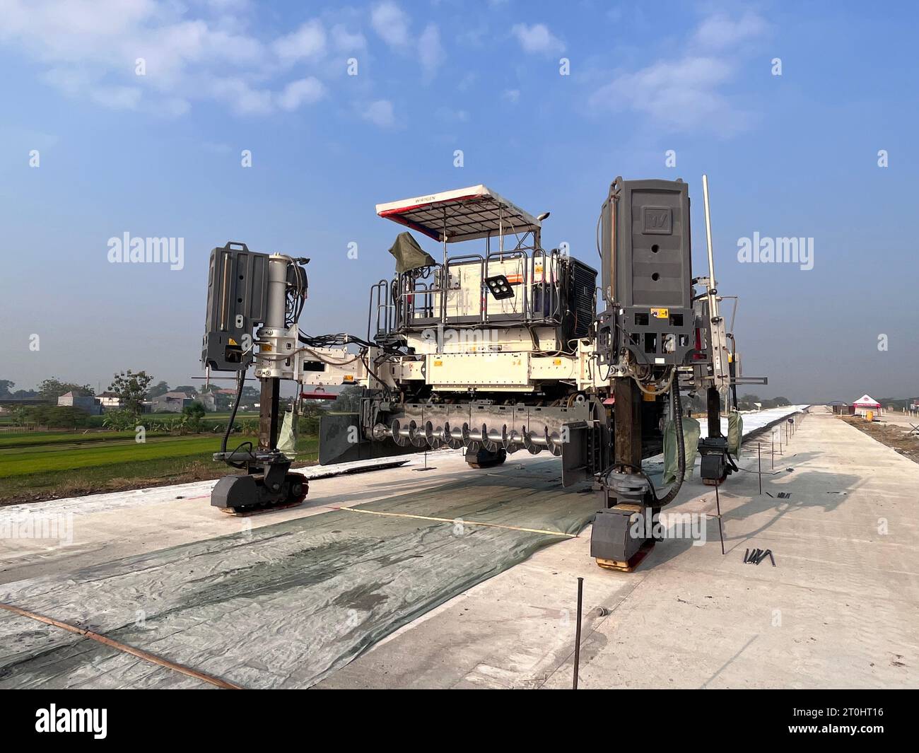 machine. Finisseur Slipform sur des travaux routiers sur un chantier de construction. Pavage routier en béton dans le nouveau quartier. Réparation de routes en béton à l'aide de nouvelles technologies Banque D'Images