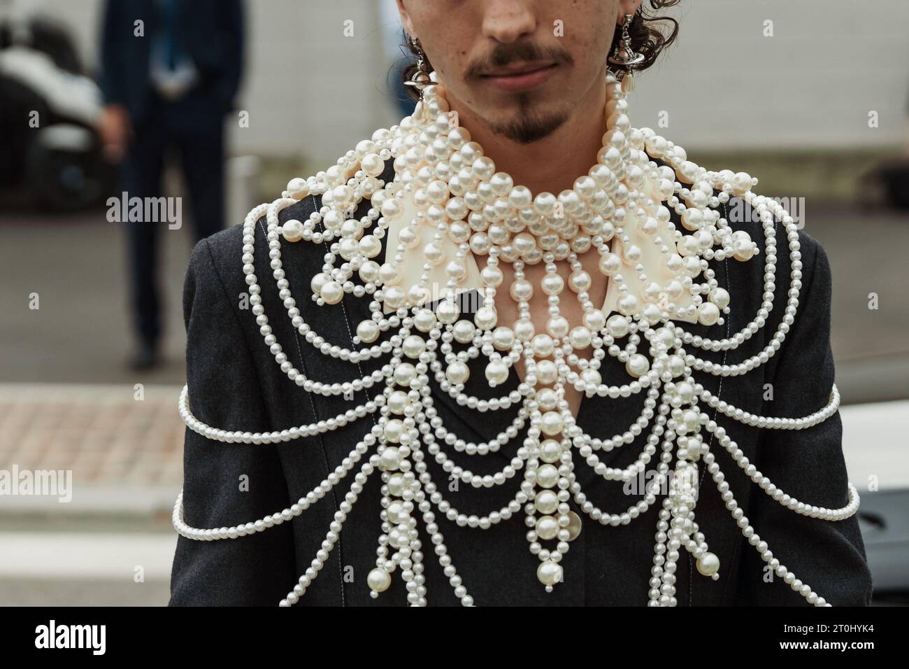Un invité porte un collier cape en perles blanches, vu à l'extérieur du salon PRADA pendant la Fashion week de Milan vêtements pour femmes Printemps/été 2024. Banque D'Images