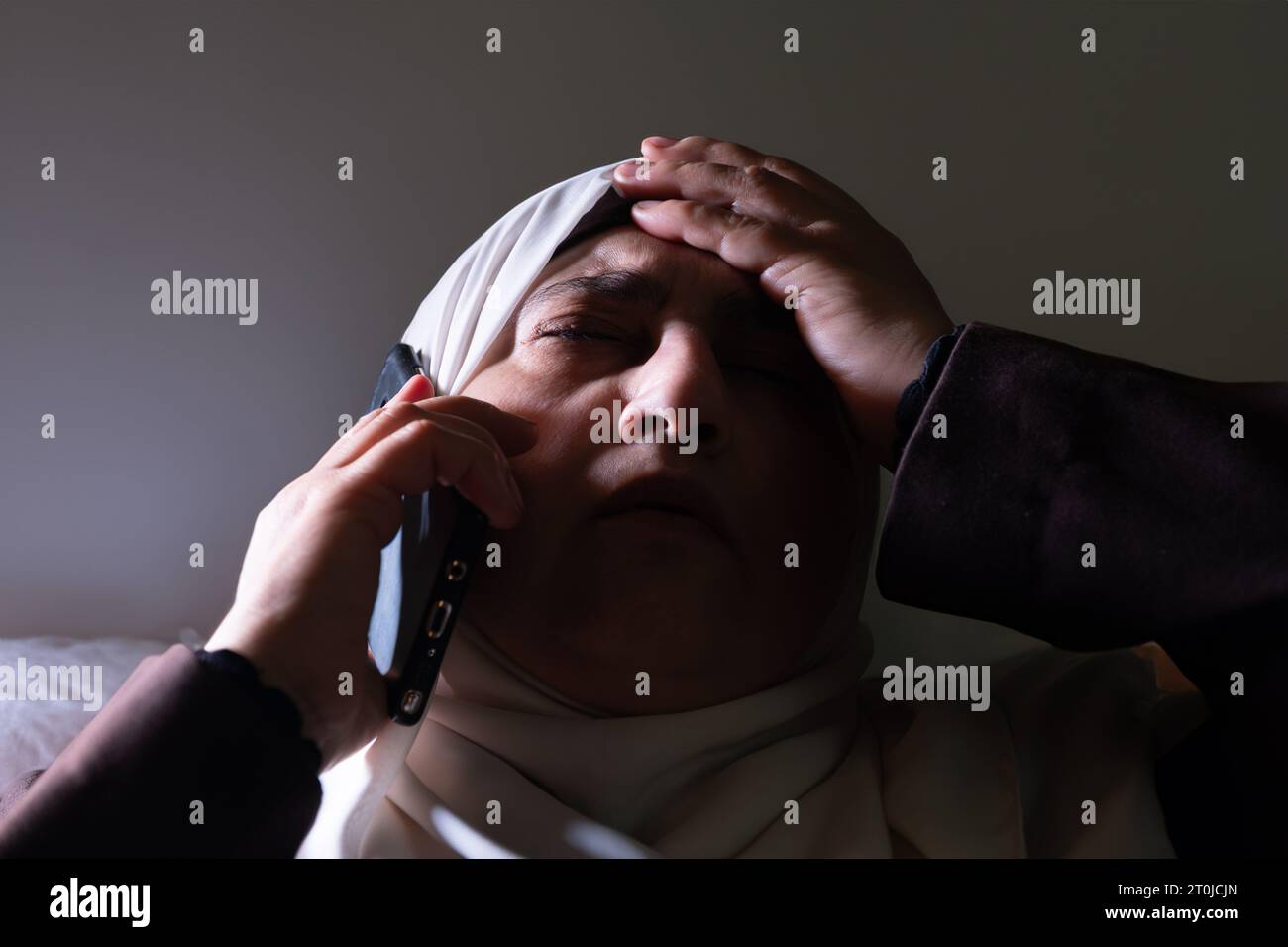 Une femme musulmane a été informée par appel téléphonique de nouvelles choquantes ou de malheurs, et son expression montre l'impuissance et la peur. Banque D'Images