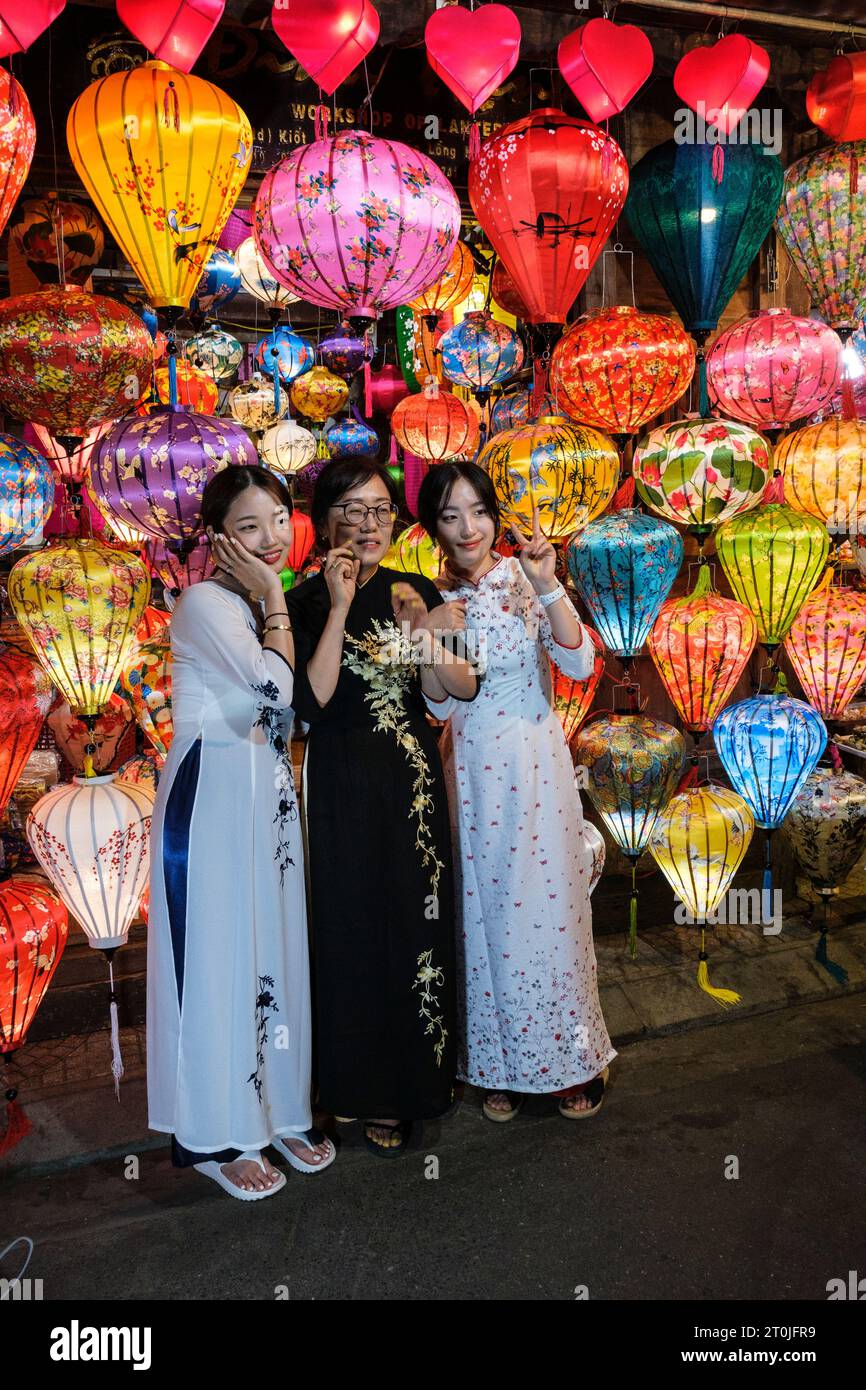 Hoi an, Vietnam. Trois femmes posant devant des lanternes à vendre. Banque D'Images