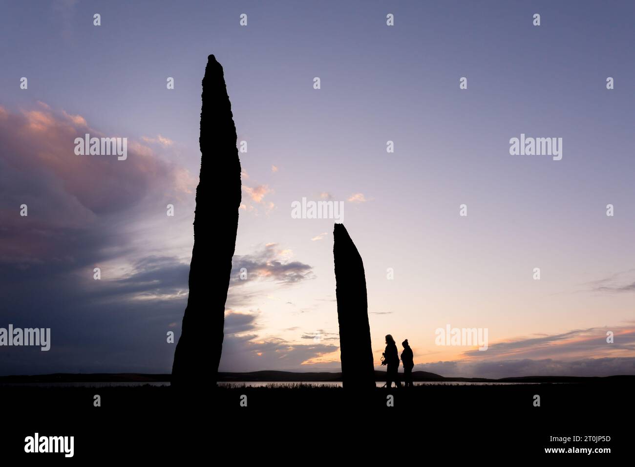 Stenness, Orcades, Royaume-Uni. 7 octobre 2023. Deux touristes visitent les magnifiques Standing Stones of Stenness au coucher du soleil, dans les Orcades, Royaume-Uni. Les énormes pierres de Stenness sont tout ce qui reste d'un grand cercle de pierres sur un ancien site cérémoniel qui date de 5000 ans. Crédit : Peter Lopeman/Alamy Live News Banque D'Images