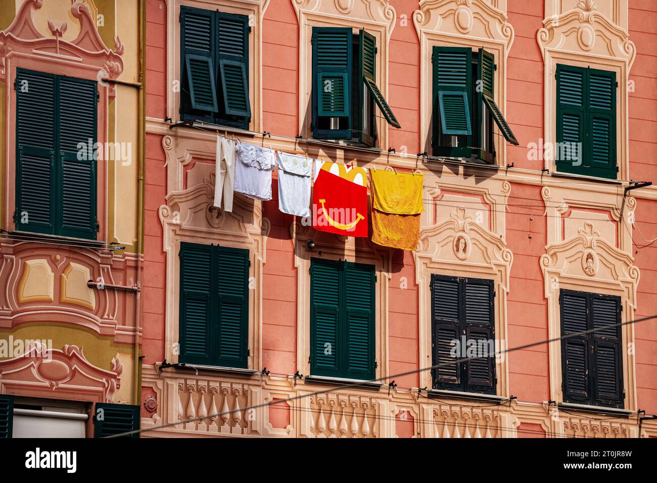 Une vieille maison historique en Europe séchant des vêtements sur une corde à linge de la fenêtre avant dans le chaud soleil d'été. Banque D'Images
