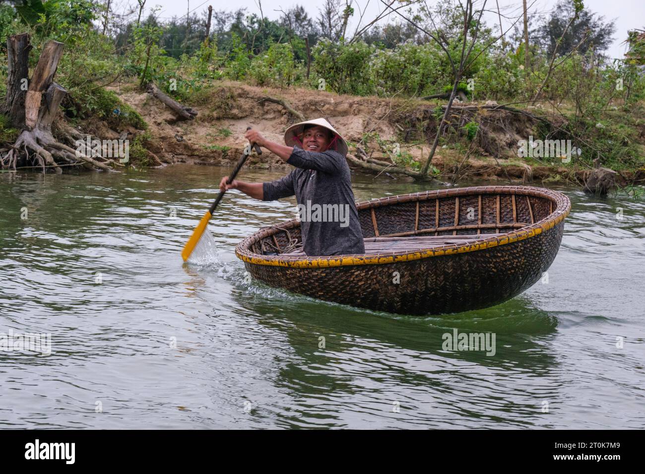 Hoi an, Vietnam. Homme dans un bateau de panier de bambou. Banque D'Images