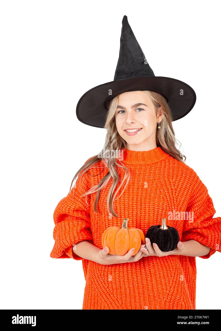 Concept de célébration d'Halloween. Portrait d'une fille souriante dans un chapeau noir tenant des citrouilles décoratives sur un fond blanc. Décoration Halloween. Banque D'Images