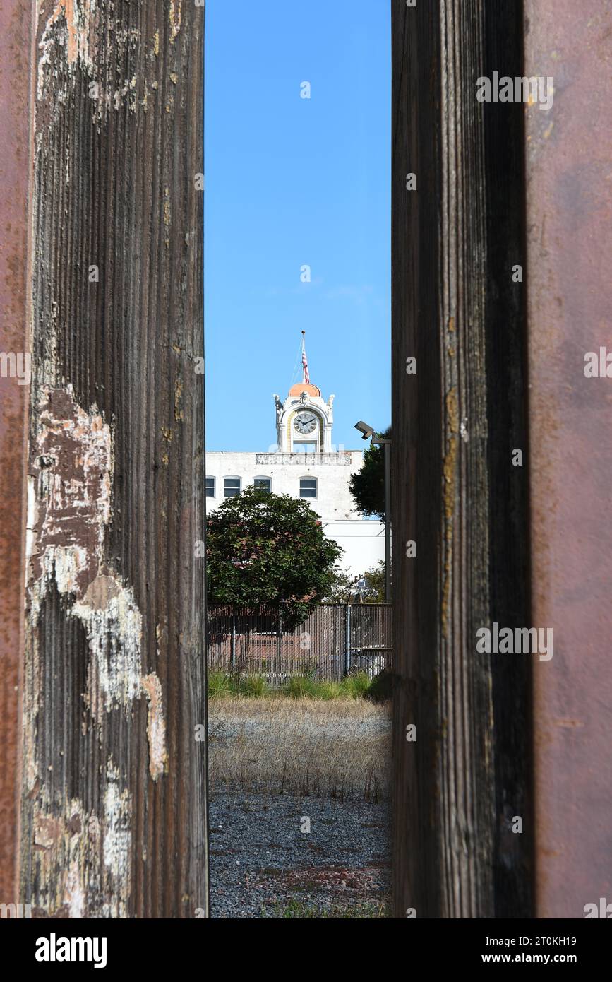 SANTA ANA, CALIFORNIE - 2 octobre 2023 : la tour de l'horloge du bâtiment Spurgeon vue à travers une clôture dans le quartier des artistes. Banque D'Images