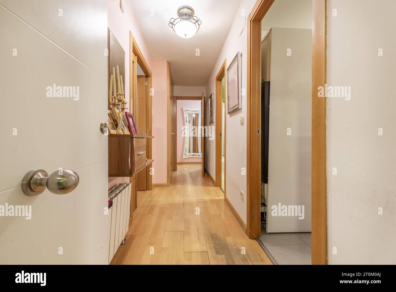 Couloir d'une maison avec porte blindée en bois blanc avec un long couloir Banque D'Images