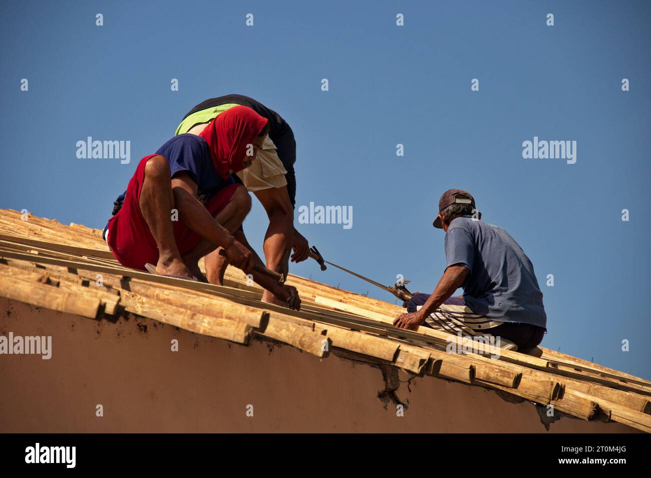 Travailleur de la construction pendant le travail sur la structure du toit du bâtiment, Indonésie Banque D'Images